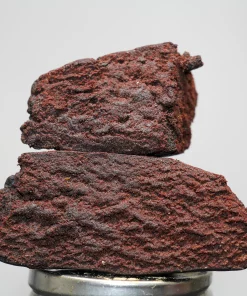 Stack of dark chocolate brownies stacked on a metal bottle cap, with a Kush Buddy watermark in the corner.