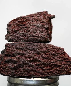 Stack of dark chocolate brownies stacked on a metal pedestal, with a Kush Buddy watermark in the bottom-left corner.