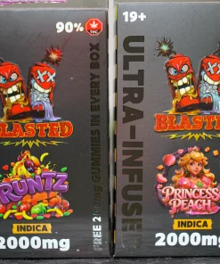 Two dark packaging boxes for cannabis products standing side by side, featuring cartoon red characters and the word BLASTED with INDICA and 2000mg text visible.